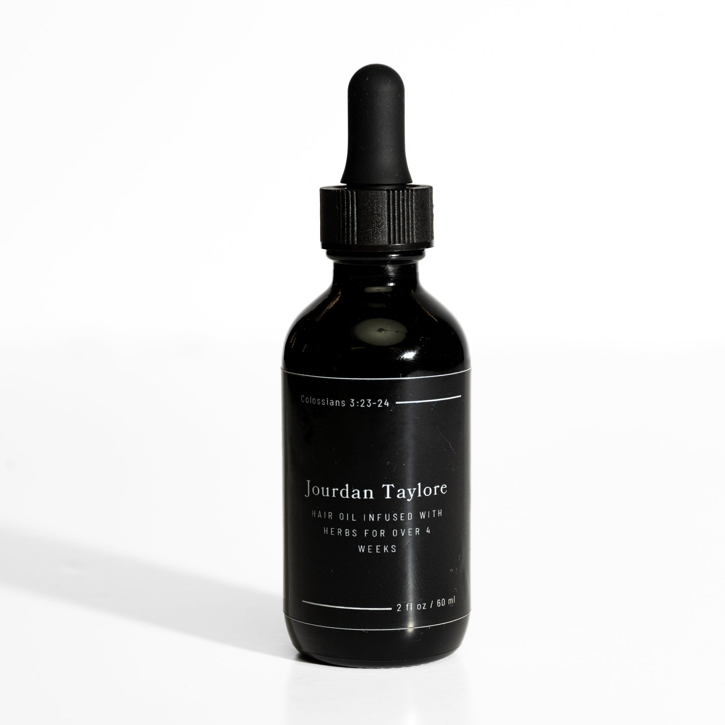 A black bottle with a dropper filled with a golden-brown hair oil, labeled as 'Medicinal Hair Elixir' by Jourdan Taylore.